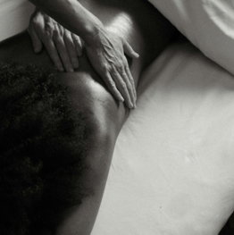 a-person-laying-on-a-bed-with-their-hands-on-their-back.jpg a person laying on a bed with their hands on their back